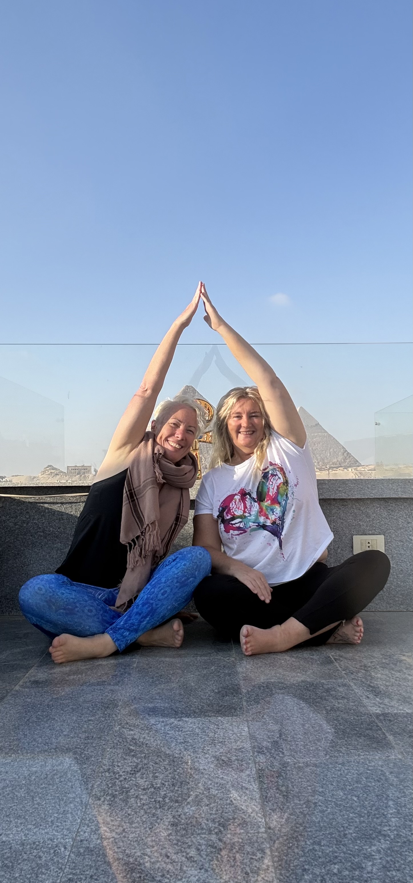 Mel Craven and Mystic Nic seated together with the pyramids behind them