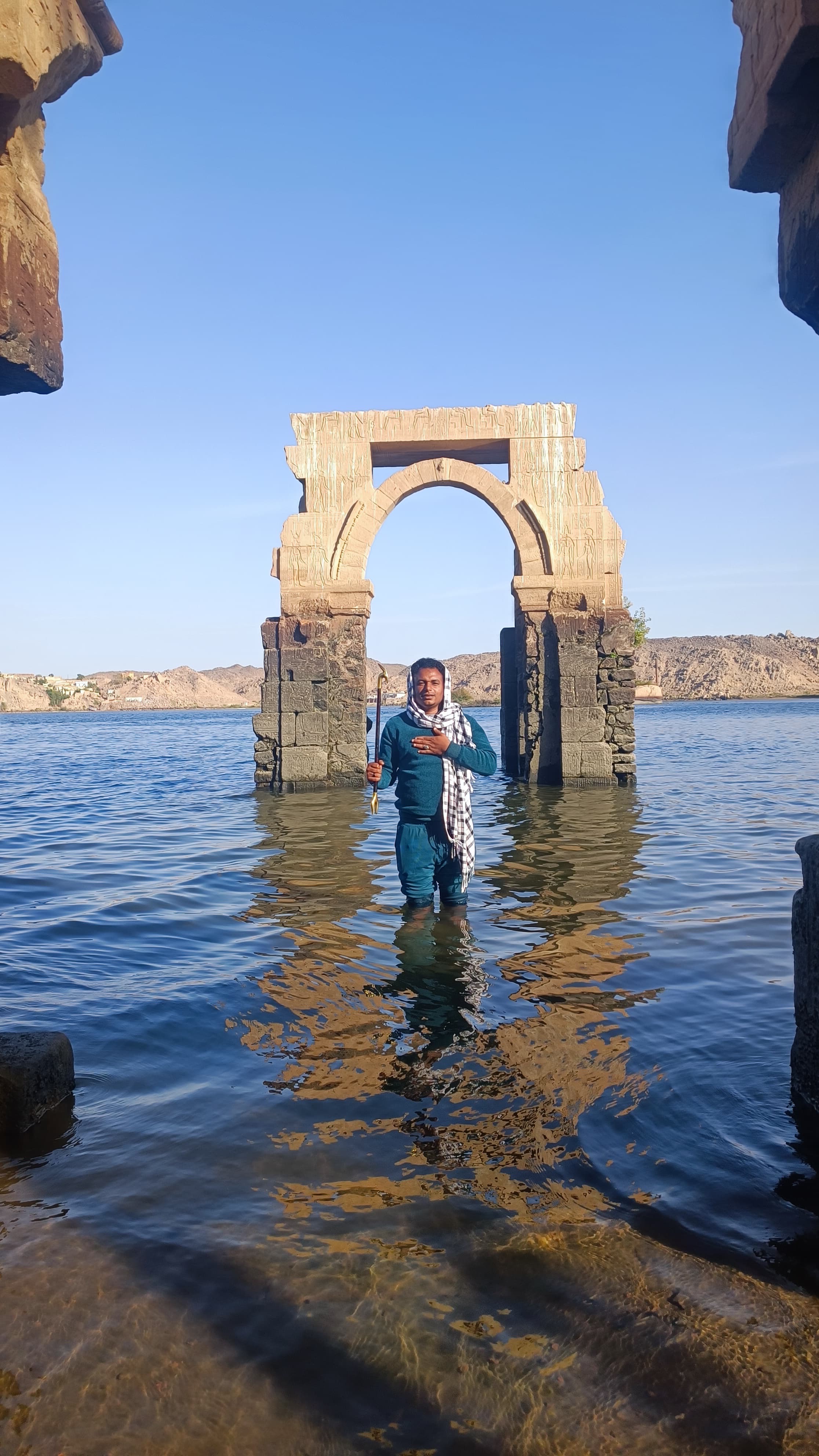 Pop Adam standing in the sacred waters by the Isis Gate at Philae