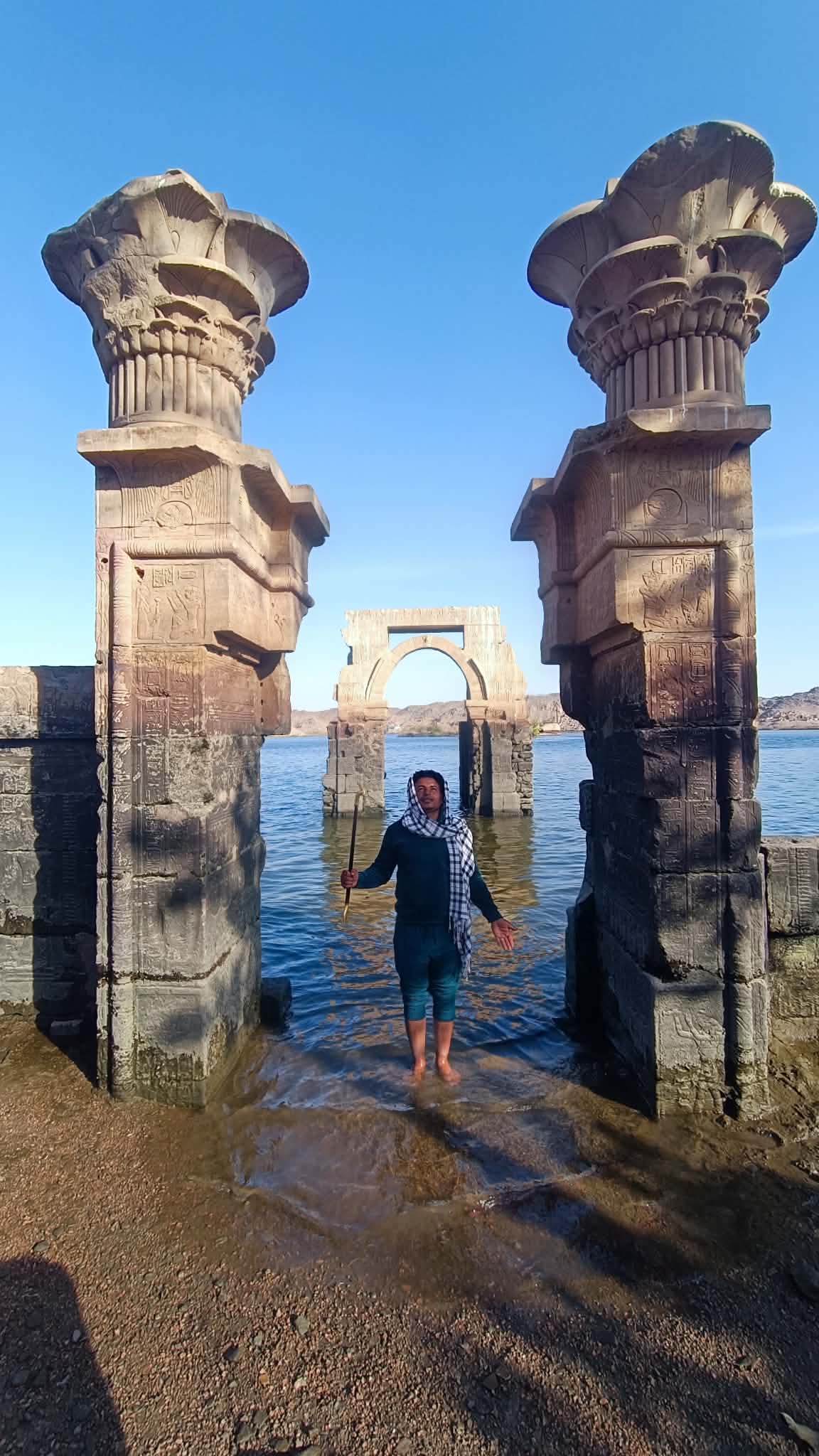 Local Egyptian guide standing at the Gates of Isis at Philae